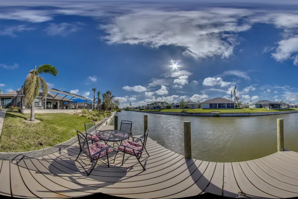 360° view of the dock with seating beside the canal, the lawn and the back of the house behind