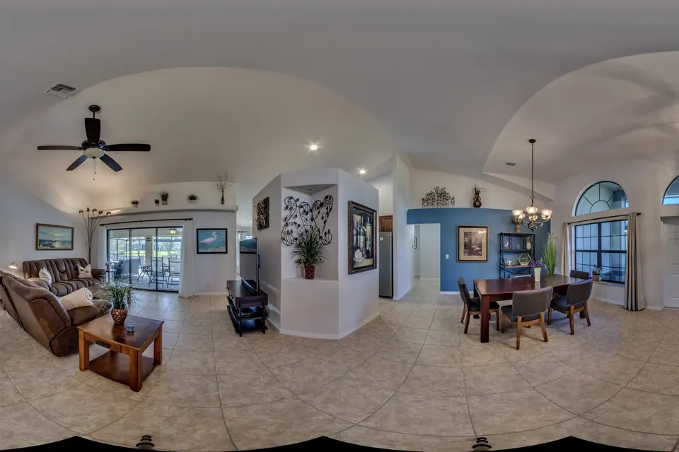 360° view of the open living and dining area with sofa, dining table and large windows